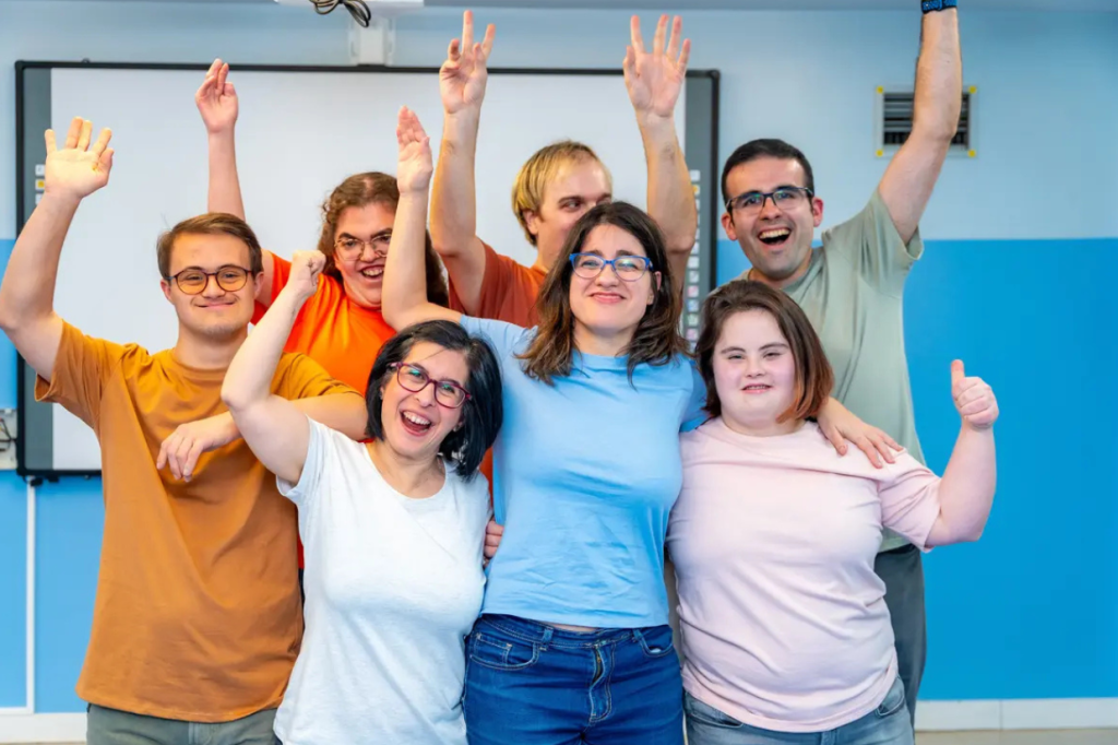 Group of friends with Down syndrome smiling at the camera after a group yoga session
