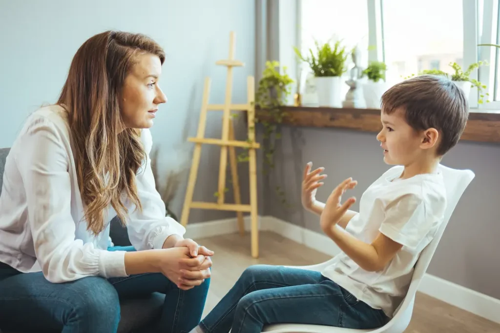 Young boy in a therapy setting talking to his female counsellor