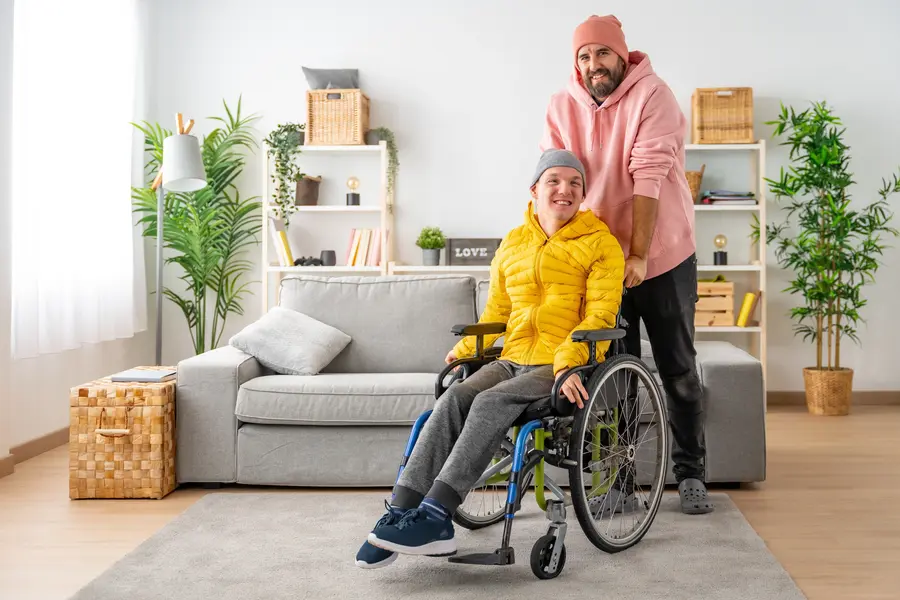 Man in wheelchair being supported by his male support worker